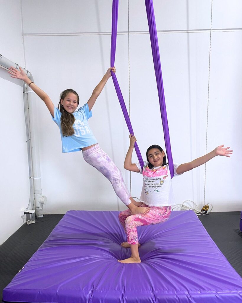 2 students doing a trick on the hammock